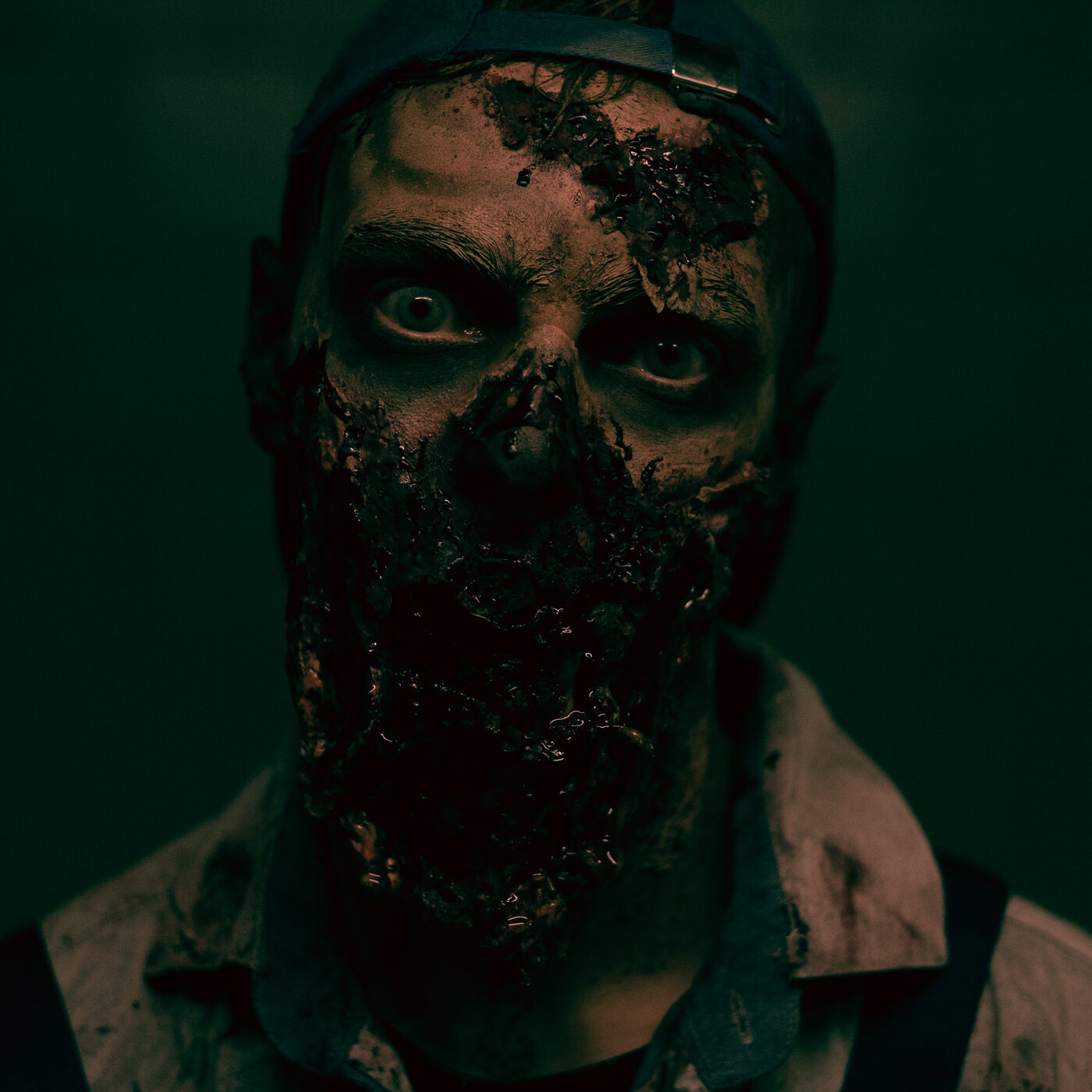 Darsteller mit realistischem Zombie-Make-up im Halbdunkel